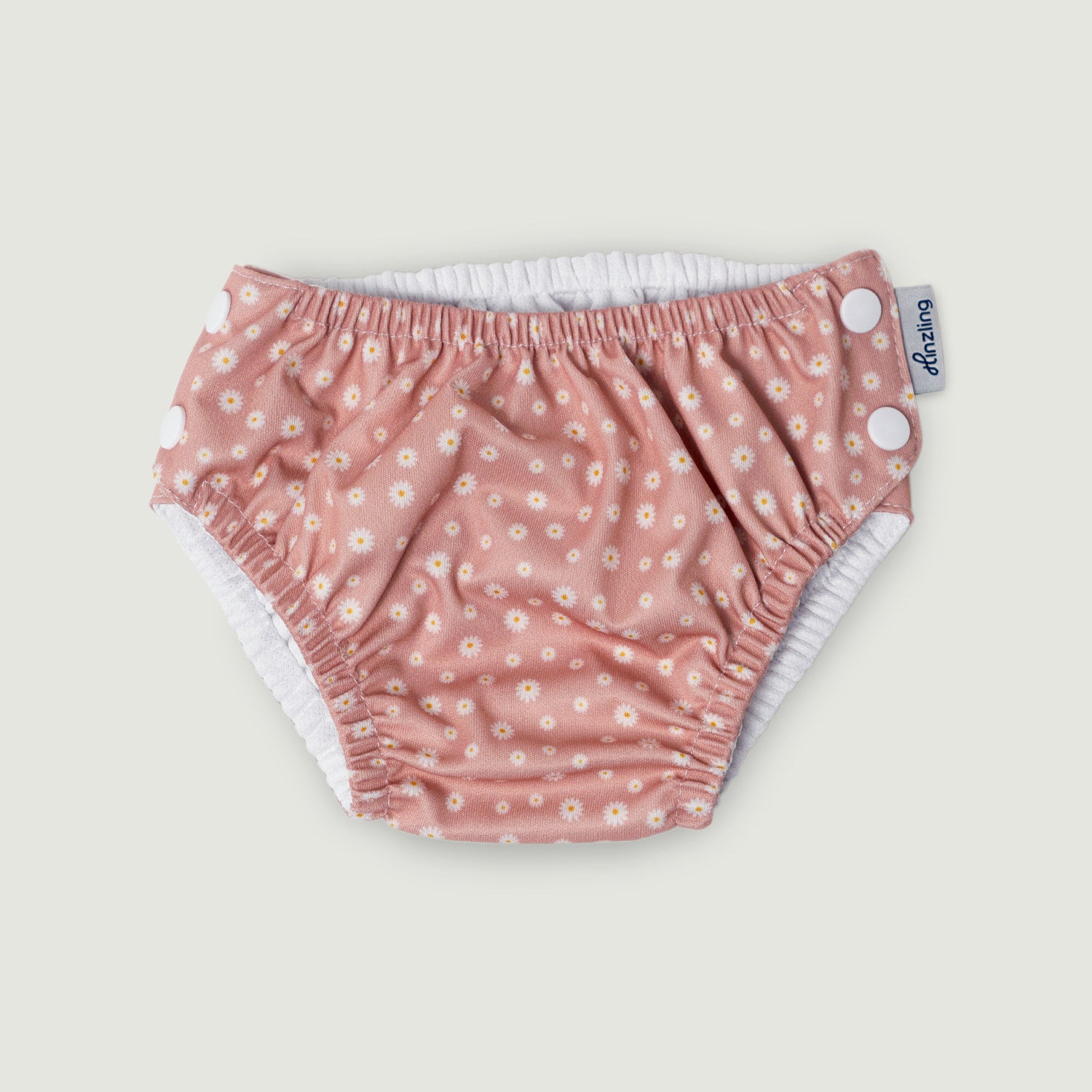 Schwimmwindel mit rosa Farbe und kleinen Blumen als Muster auf weißem Hintergrund